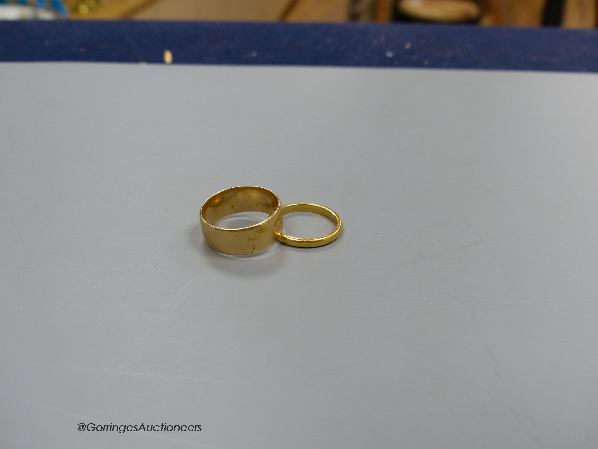 An 18ct. gold wedding band, size P, 5.9g, and a 22ct gold band, size L, 2.9g.